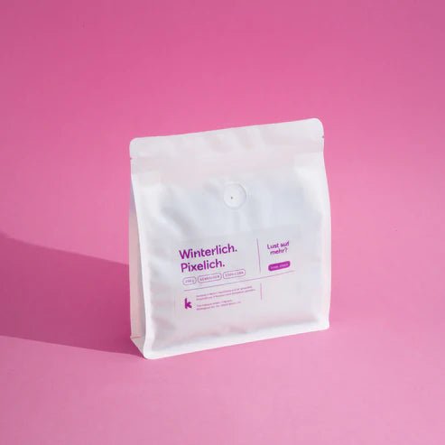 Winterlich Pixelich Filterkaffee – weiße Verpackung mit lilafarbenem Text auf rosa Hintergrund