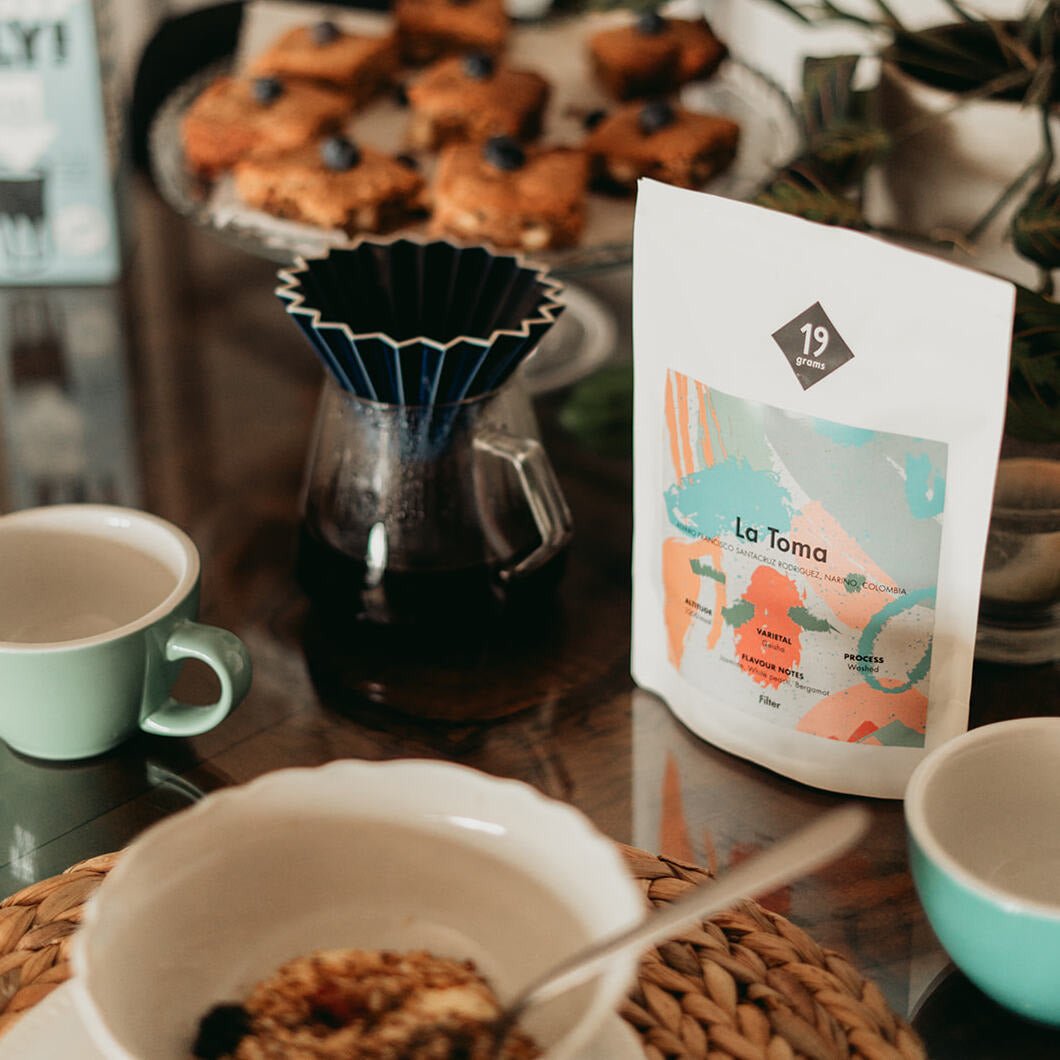 19grams La Toma Geisha Kolumbien 250g Kaffeebeutel auf Frühstückstisch mit Dripper und Kaffeetasse – Specialty Coffee Filterkaffee von 19grams Berlin