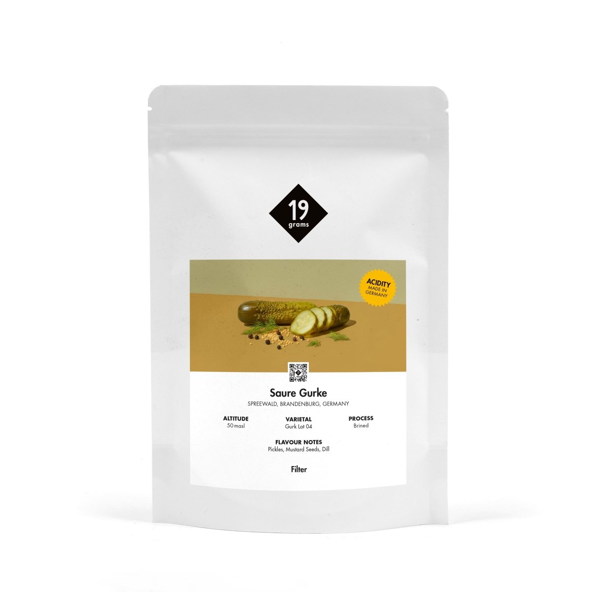 Produktmockup der 19grams Kaffeeverpackung „Saure Gurke" mit olivgrüner Banderole und Gurkenmotiv auf weißem Hintergrund