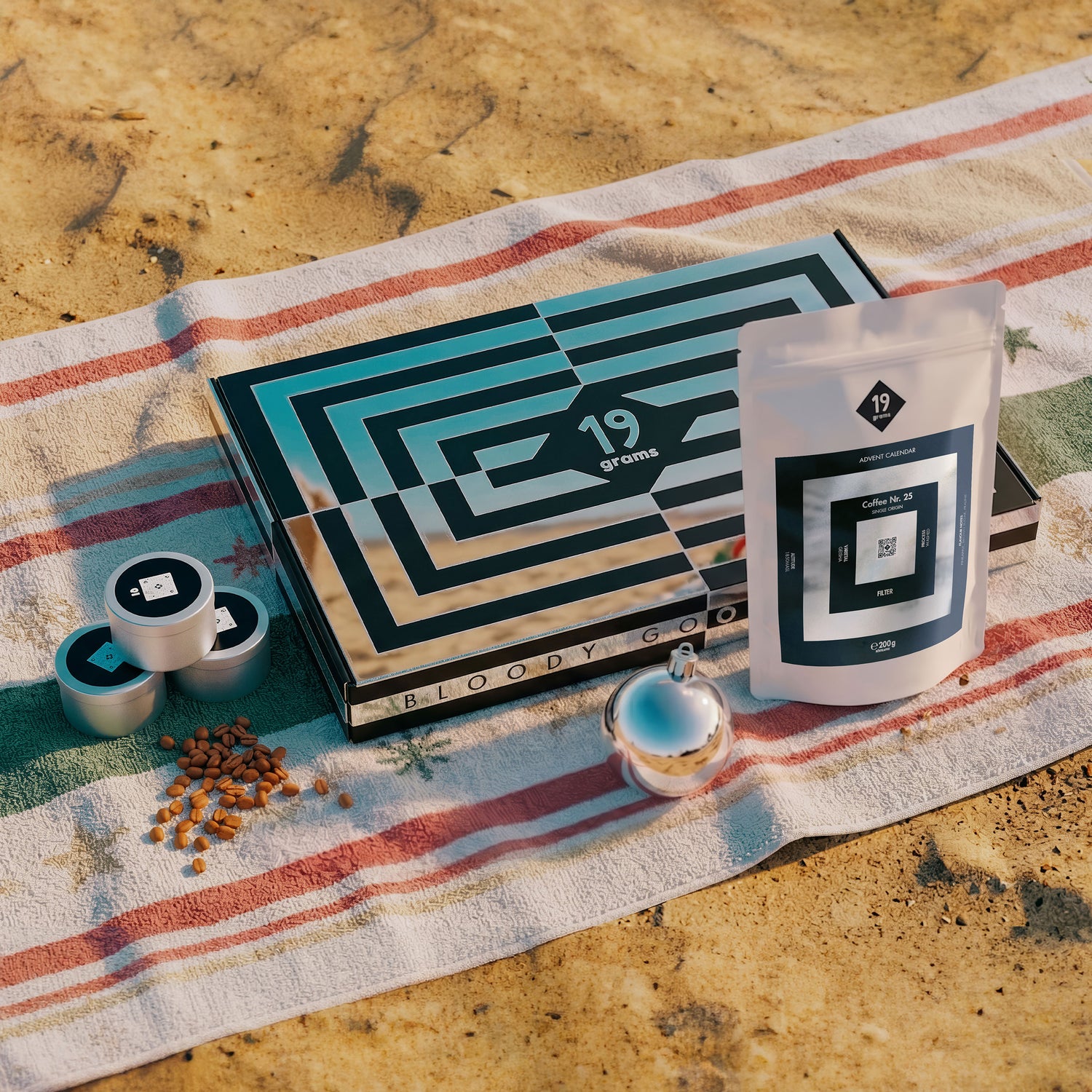 19grams Xmas in July Specialty Coffee Moodbild – Adventskalender Box mit Kaffeebeutel, Kaffeedosen und Kaffeebohnen am Strand, Bloody Good Coffee, Kaffeerösterei Berlin