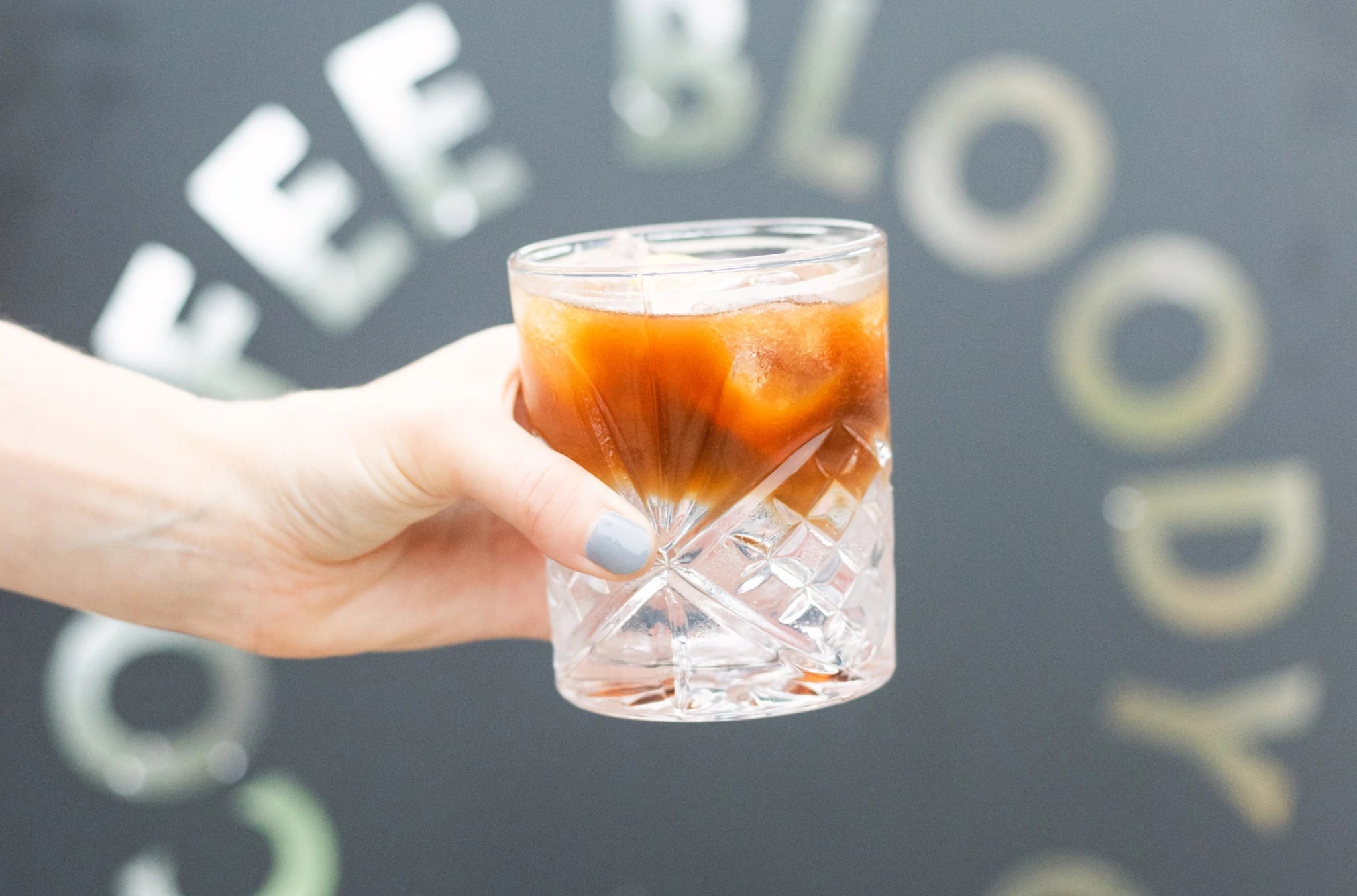Holding a 19grams espresso tonic in front of a bloody good coffee sign at 19grams Cafe and roastery in Alexanderplatz Berlin