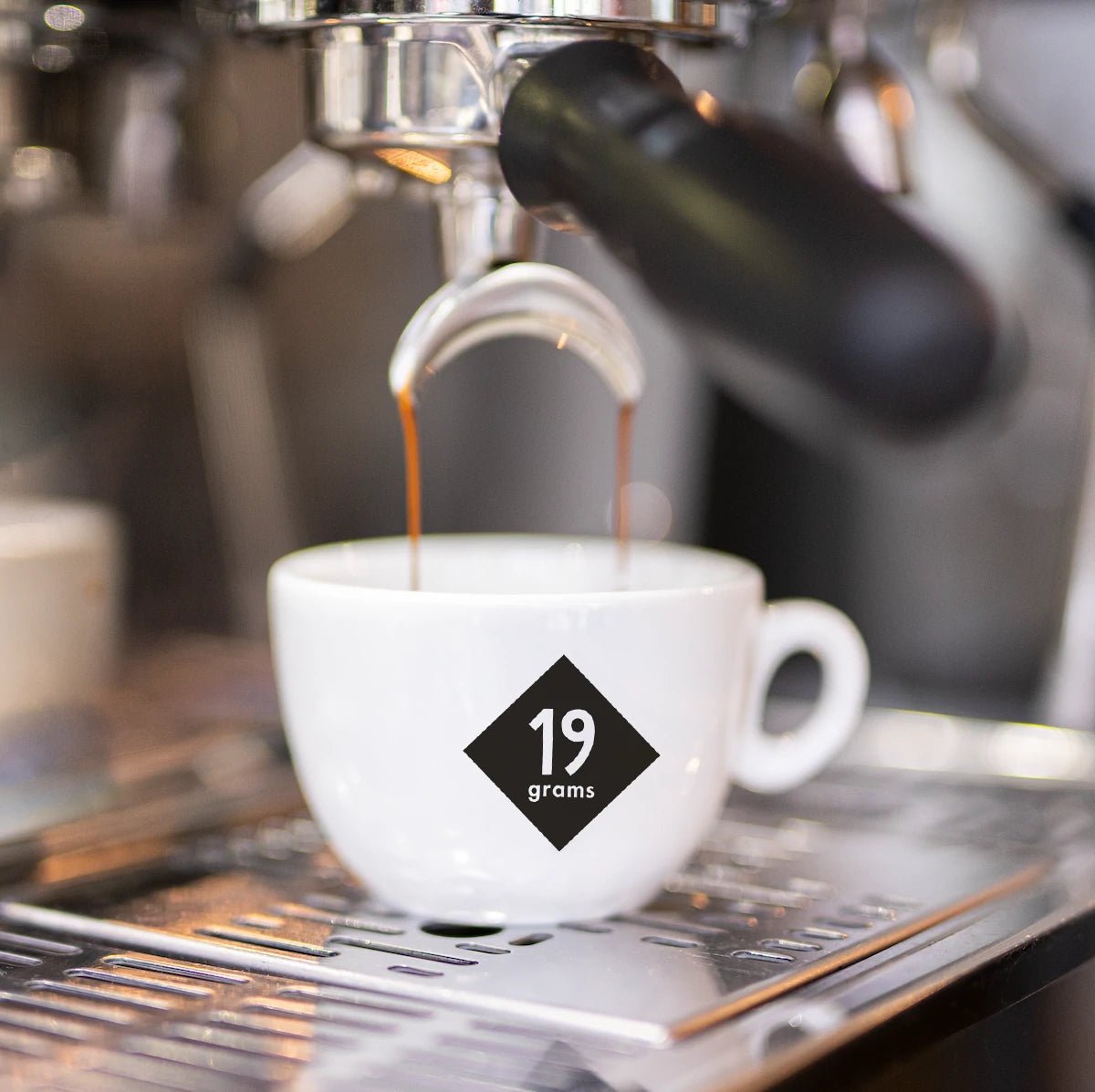 Espresso fließt in eine 19grams Markentasse aus dem Siebträger – Frisch gezogener Espresso bei 19grams.live Roasters Berlin