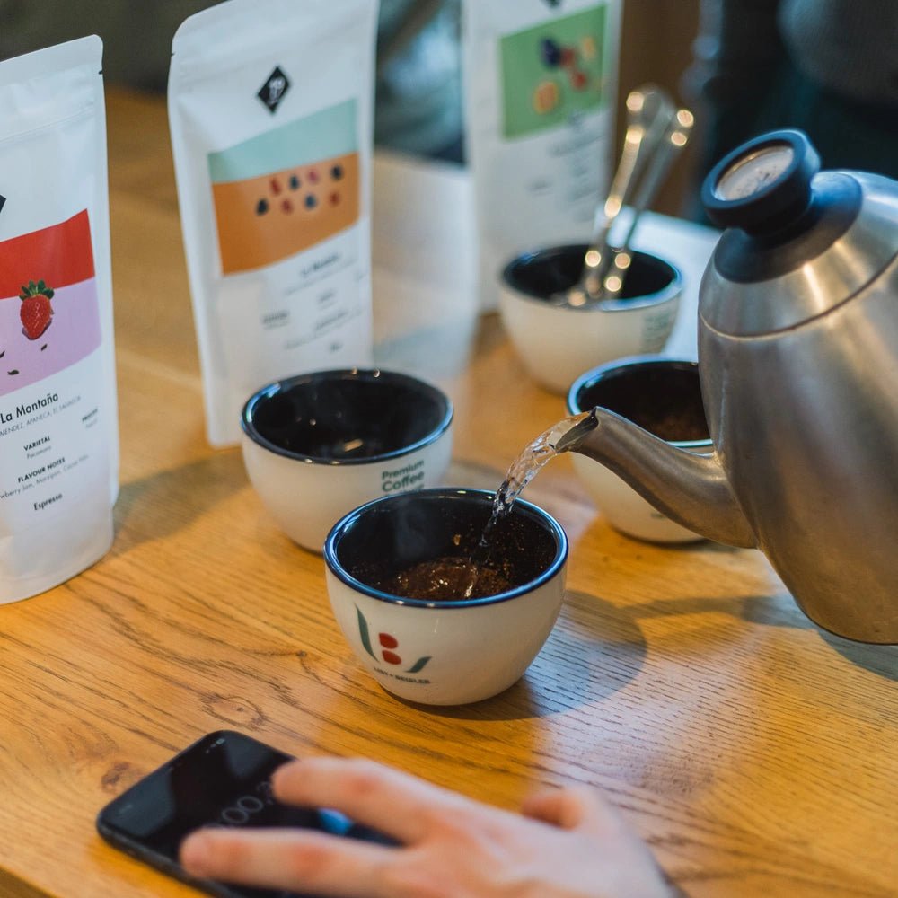 Kaffeekanne gießt Wasser in Cupping-Schale beim 19grams Kaffee-Training mit Arundhati Shenoy – Sensorik Workshop mit verschiedenen 19grams Specialty Coffee Büteln, Berlin