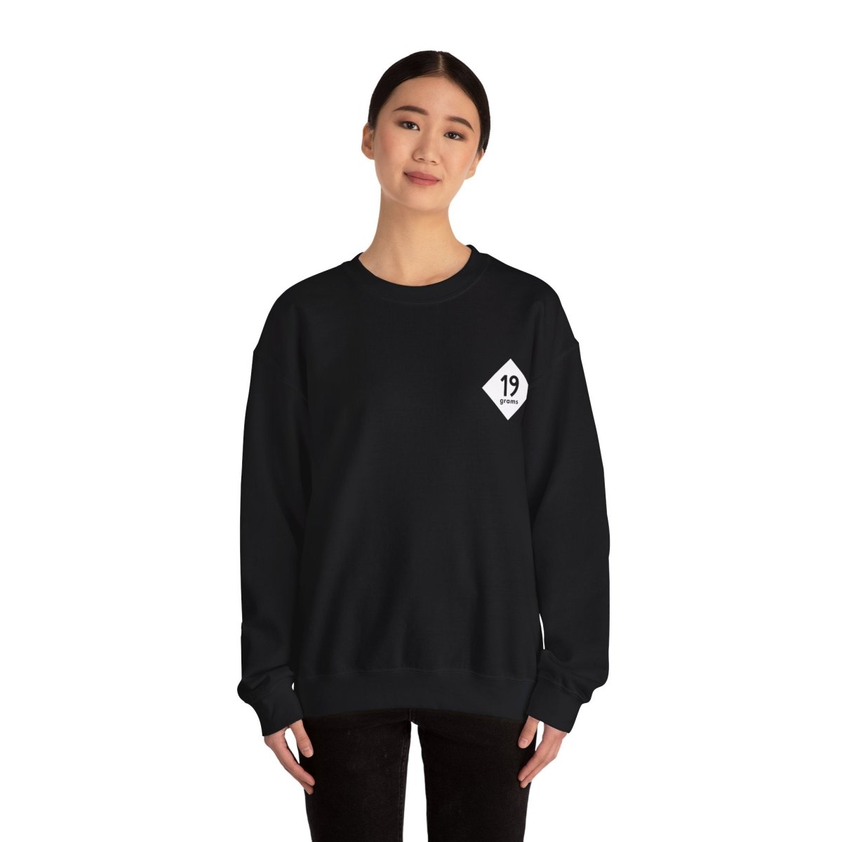 19grams schwarzer Pullover mit weißem 19grams Logo auf der linken Brust, getragen von einer Frau, Frontansicht