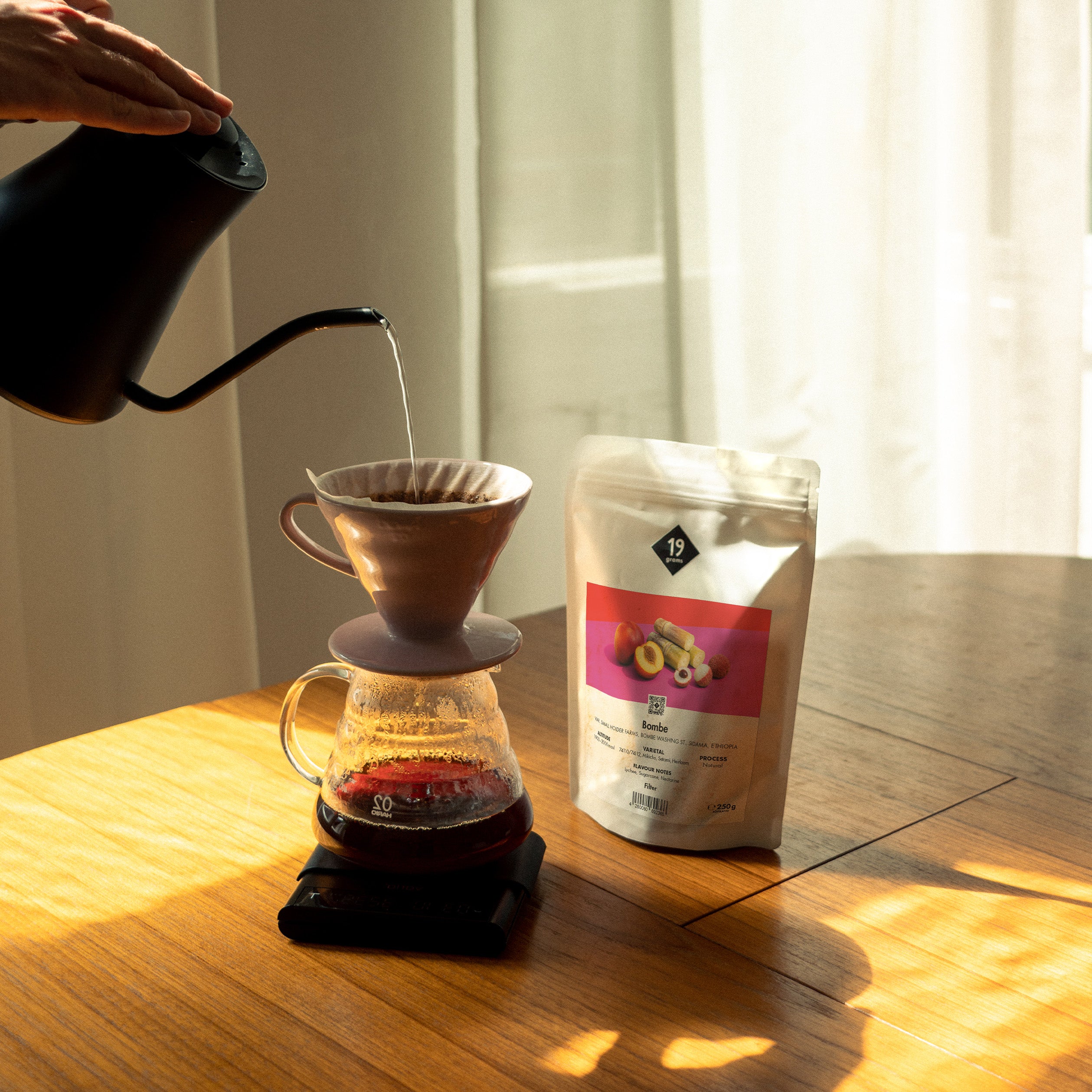 19grams Bombe Specialty Coffee Filter – Handaufguss mit Kaffeebeutel auf Holztisch im Sonnenlicht, Kaffeerösterei Berlin