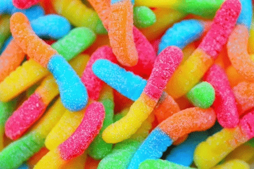 Bunte gezuckerte Candy-Sticks in Gelb, Orange, Rot und Blau – Aromabild für süß-fruchtige Kaffeenoten bei 19grams