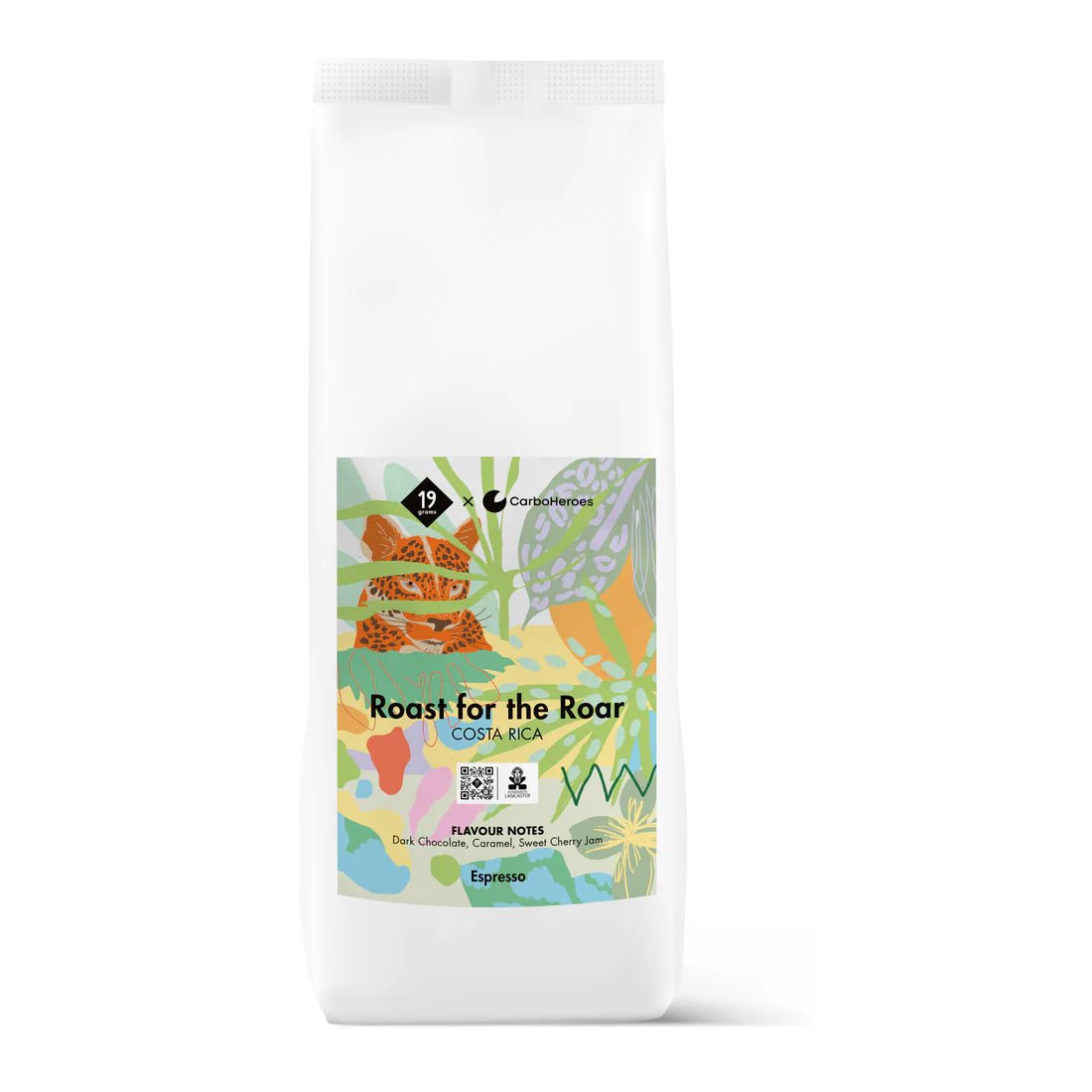 Weißer Kaffeebeutel mit farbenfrohem Etikett, das Pflanzenmotive und den Text "Roast for the Roar" sowie "Espresso" zeigt.