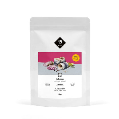 Produktmockup der 19grams Kaffeeverpackung „Rollmops" mit pinker Banderole und Rollmops-Motiv auf weißem Hintergrund