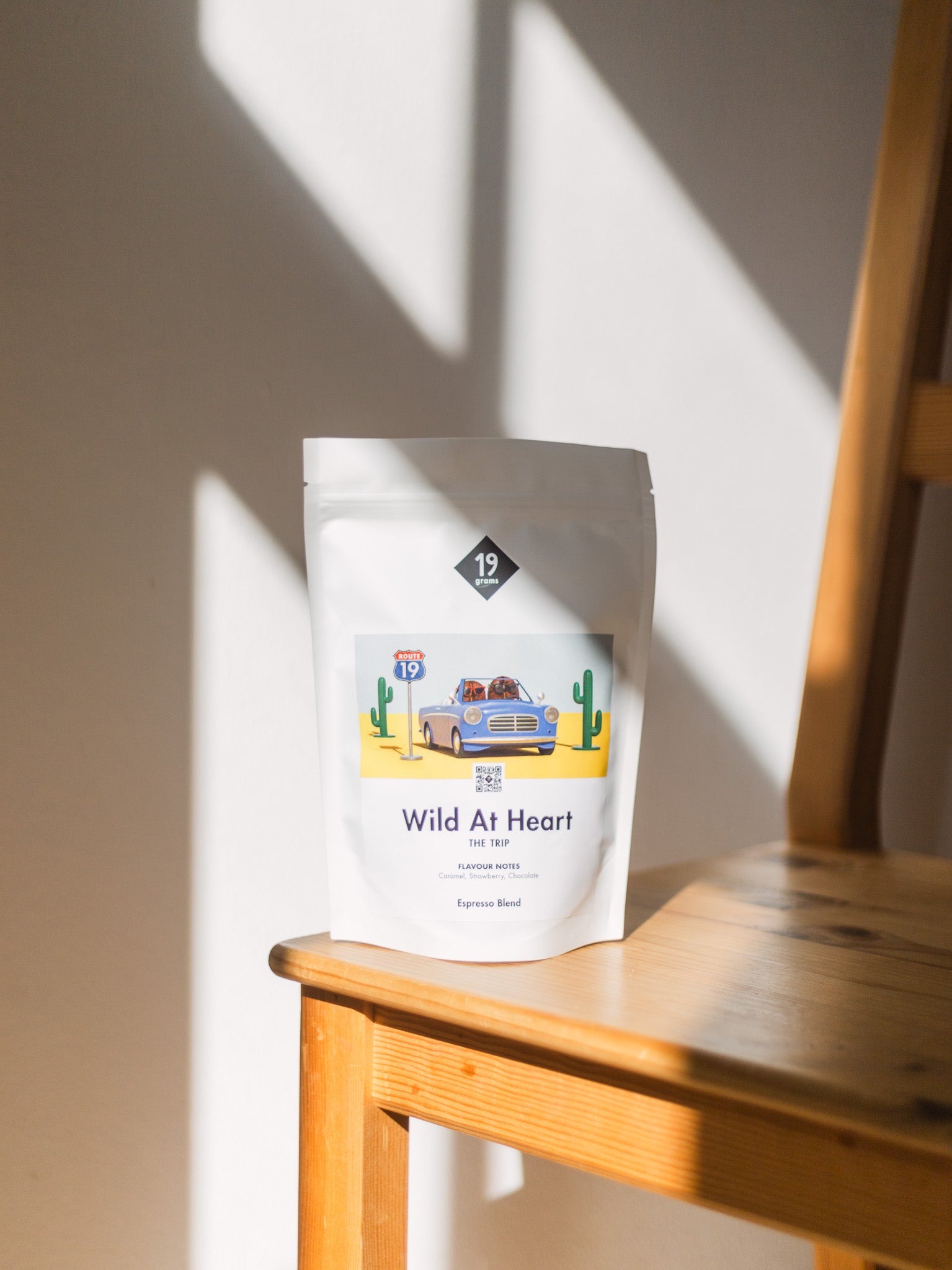 19grams Wild At Heart The Trip Espresso Blend Kaffeebeutel auf Holzstuhl – Specialty Coffee Produktfoto Rösterei Berlin